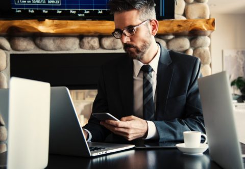 a businessman with a smartphone and laptop