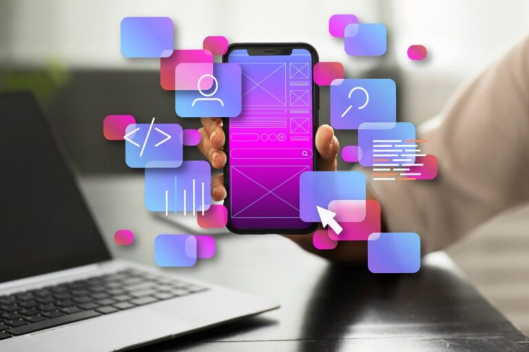 Hand holding a smartphone with app UI/UX design elements floating around, symbolizing app development